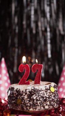 Pastada 27 numaralı mumları yakmak. Yirmi yedinci yaş günü pastası. Ağır çekim. Boşluğu kopyala