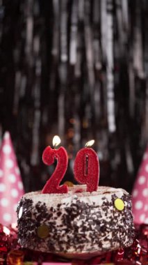 Pastada 29 numaralı mumları yakmak. Yirmi dokuzuncu yaş günü pastası. Ağır çekim. Uzayı kopyala Dikey görünüm