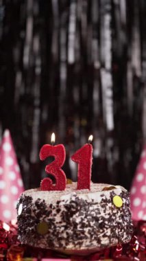 Pastada 31 numaralı mumları yakmak. Otuz birinci yaş günü pastası. Ağır çekim. Uzayı kopyala Dikey görünüm
