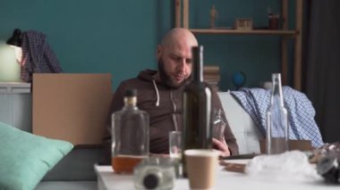 Evde alkol alan bir adam. Alkol bağımlılığı. Bunaltıcı düşünceler. Alkol bağımlılığı sorunu konsepti. Boşluğu kopyala