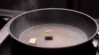 Kızartma tavasında bir tutam biberiyeyle tereyağı yakın plan, kızarmış ete hazırlanıyor. Yakın plan.