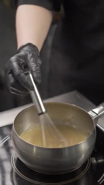 レストランのキッチンでクリームスープやチーズソースを調理するシェフ バーティカルビデオ — ストック動画