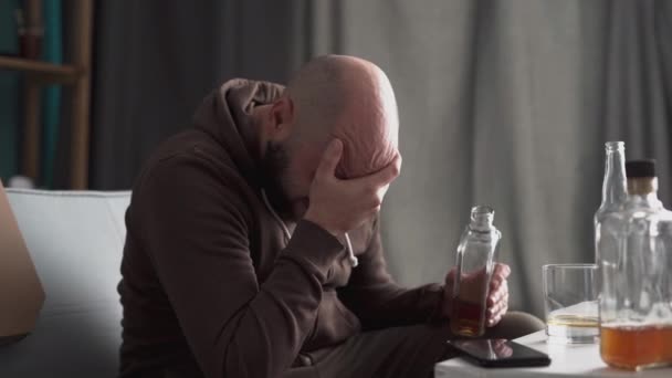 Ένας Καταθλιπτικός Άντρας Κλαίει Πίνοντας Ουίσκι Στο Σπίτι Καθισμένος Στον — Αρχείο Βίντεο