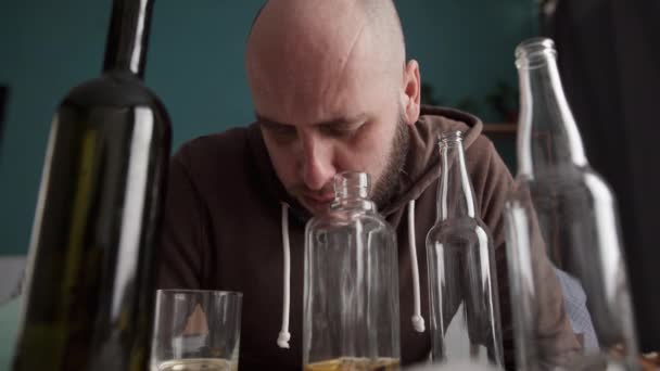 Bêbado Entre Garrafas Vazias Sentadas Mesa Conceito Alcoolismo — Vídeo de Stock