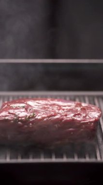 Şef ızgarada sığır filetosu pişiriyor. Yaz ve ızgara et konsepti. Dikey video