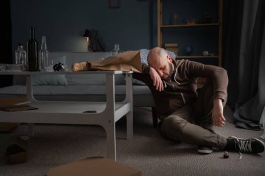 Bardaklı ve şişeli erkek alkolik oturma odasında uyuyor. Alkolizm, alkol bağımlılığı ve insan konsepti. Boşluğu kopyala