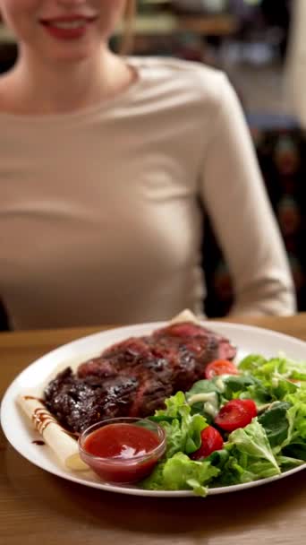 レストランの顧客にサラダとグリル肉を提供するハンドウェイター コンセプトを提供するレストラン バーティカルビデオ — ストック動画