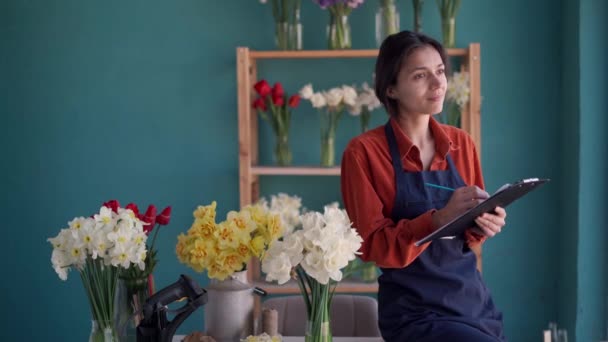 Virágüzlet Tulajdonosa Kötényt Hord Kezében Írótáblával Miközben Leltározik Virágáruházában Fénymásolási — Stock videók