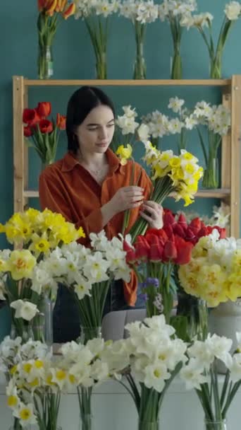Молода Брюнетка Жінка Флорист Обгортає Букет Нарцисами Паперовій Упаковці Магазині — стокове відео