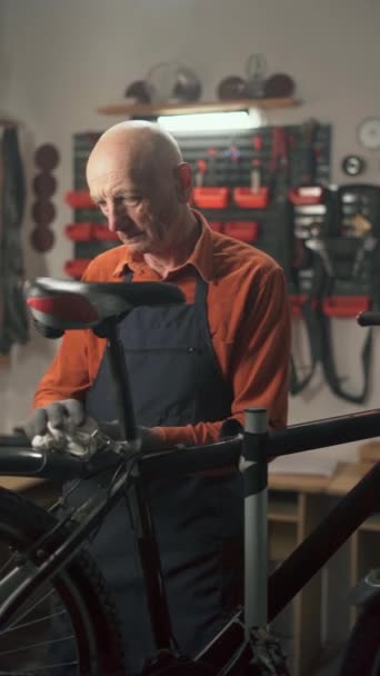 Staruszek Naprawiający Rower Warsztacie Wycierający Szmatą Konserwacja Rowerów Garaż Concept — Wideo stockowe