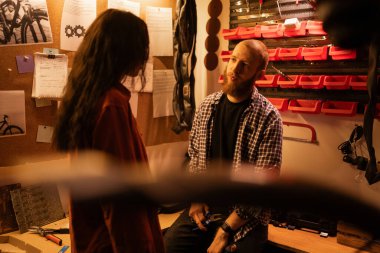 Garajda bisiklet tamiri. İş arkadaşları ya da arkadaşlar kırık bir bisiklet parçasından bahsediyorlar. Boşluğu kopyala