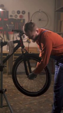 Bisiklet tamircisi bisiklet atölyesinde ya da otantik garajda çalışan bir tekerleği söküyor. Bisiklet tamir konsepti. Boşluğu kopyala