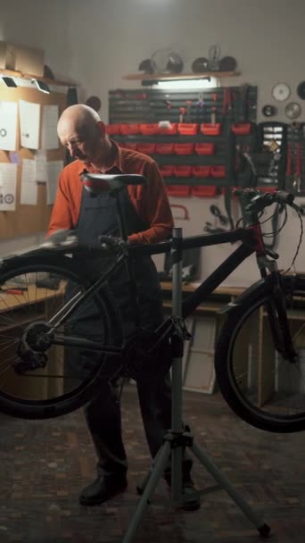 老人在车间里修理自行车 用抹布擦拭 自行车维修和车库概念 垂直录像 — 图库视频影像