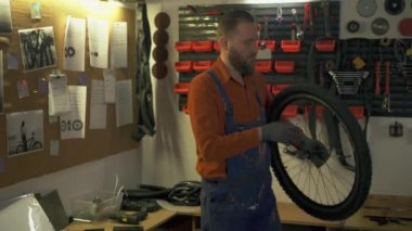 Bisiklet tamircisi atölyede ya da garajda bisiklet tamir ediyor. Bisiklet bakım ve onarım konsepti