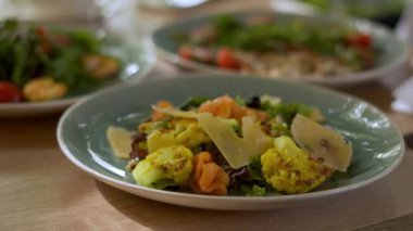 Marullu salata, kızarmış karnabahar ve restoranda peynir yiyen bir kadın.