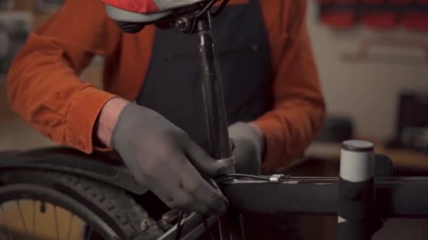 ガレージや修理工場に立っている自転車の高さを調整するバイク修理士 コピースペース — ストック動画