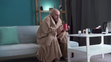 Millennial hasta adam kanepede oturmuş grip yüzünden acı çeken çayını içiyor. Boşluğu kopyala