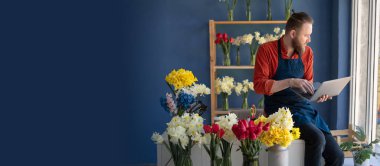 İş yerinde dizüstü bilgisayar kullanan profesyonel bir çiçekçi. İnternette çalışan küçük işletme sahibi. Boşluğu kopyala