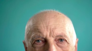 Yaşlı adam alnına dokunuyor. İş adamının başı ağrıyor ve aşırı çalışmaktan başı ağrıyor. Stres ve yorgun konsept.