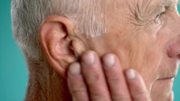 一位老人用手抚摩他那酸痛的耳朵的特写 侧面看 — 图库视频影像