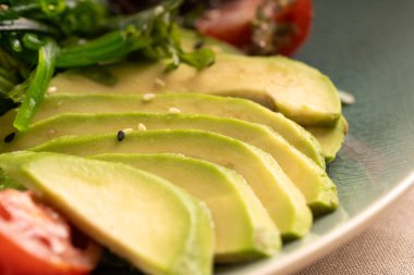 Sağlıklı kahvaltı ya da atıştırmalık olarak sebzeli avokado dilimi. Yakın plan.