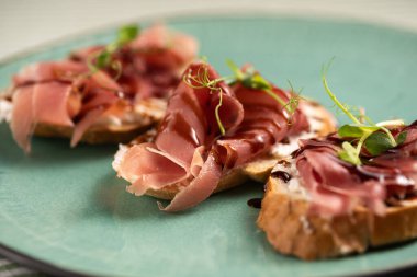 Pişmiş jambonlu kızarmış ekmek. İtalyan jambonu ve Iberico jamon aperatifi. Yakın plan.