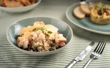 Paella İspanyol yemeği. Mavi tabakta deniz ürünleri ve tavuk pilavı. Pirinç, karides ve tavuk. Çatal ve bıçakla servis edilmiş. Boşluğu kopyala