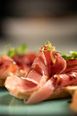 Jambonlu, soya soslu, domuz jambonlu, tabakta beyaz ekmek ile servis edilen, yakın plan.