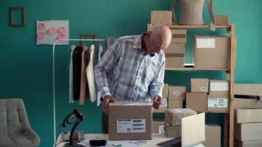 Başlangıçta küçük işletme KOBİ 'si, girişimci yaşlı adam çevrimiçi paket teslimat için ürün kutusu hazırlıyor. Boşluğu kopyala