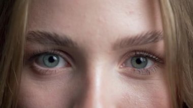 Kaşlarını çatan kadın yüzünün yakın çekimi. Mavi gözlü kız kameraya bakıyor. Öfke ve şüphecilik kavramı. Boşluğu kopyala