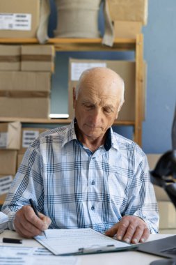 Yaşlı bir çevrimiçi dükkan sahibi teslimatı ayarlar. Küçük bir iş. Boşluğu kopyala