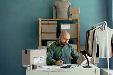 Online mağazanın sahibi paketin detaylarını belgelere yazar. Küçük bir iş. Boşluğu kopyala