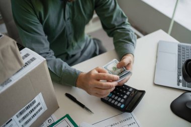 Satıcı o günkü satış gelirini yeniden hesaplıyor. Mal ve paket teslimatı. Yakın plan.