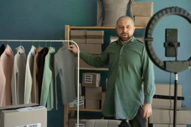 Bir çevrimiçi mağaza sahibi müşterilere yeni kıyafetler gösterir. Teslimat ve sipariş. Boşluğu kopyala