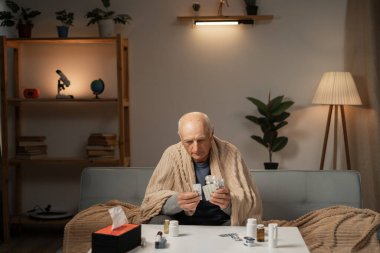 Hasta yaşlı bir adam evde tedavi ediliyor. Hastalık için hap alıyor. Boşluğu kopyala