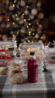 Bayram partisi atıştırmalıkları ve özgeçmişi olan meyve suyu Noel kutlamaları için mükemmel. Noel ağacının yanında çeşitli bayram atıştırmalıkları, içecekler ve dekorasyonlar var.