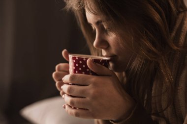 Bir kadının fincandan çay içtiği yakın plan fotoğraf. Mevsimsel hastalıkların önlenmesi. Boşluğu kopyala