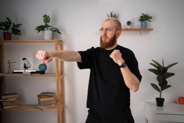 Atletik Sağlıklı Adam boks antrenmanını evde yapıyor. Genç erkek boks kardiyogramı yapıyor. Boşluğu kopyala