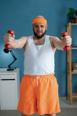 Dambılı bir adamın portresi evde egzersiz yapıyor. Spor ve sağlıklı yaşam tarzı kavramı. Boşluğu kopyala
