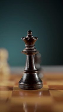 Stratejik bir oyun sırasında analiz ve gözlem için çerçeveli bir satranç kraliçesi ve şövalyesinin detaylı görüşü. Dikey video