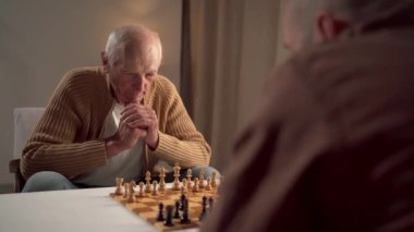 Yaşlı adam ve genç yoldaş güçlü bir konsantrasyon ve stratejik düşünce göstererek stratejik bir satranç maçına derinden odaklandılar. Boşluğu kopyala