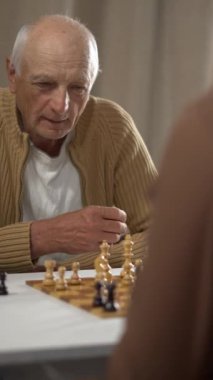 Kıdemli beyefendi stratejik düşünme becerilerini ve konsantrasyonunu sergileyerek bir satranç maçına daldı.