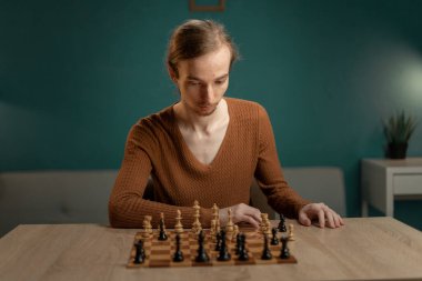 Uzun saçlı hippi evde satranç oynuyor, boş zamanlarının tadını çıkarıyor. Boşluğu kopyala