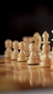 Stratejik olarak dizilmiş tahta satranç taşları profesyonel bir düzende oyun için zeka ve taktiklere odaklanıyor