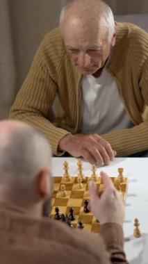 Evde satranca odaklanan yaşlı bir adam, stratejik düşünce ve konsantrasyonunu rahat bir ortamda gösteriyor.