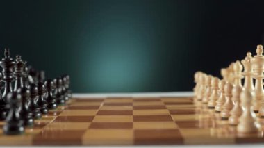 Bir satranç oyununun dinamik görüntüsü siyah ve beyaz piyonlar arasındaki kritik açılış hareketlerini gösteriyor..