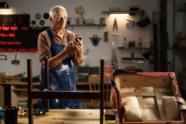 Ahşap ürünler, cep telefonu restoratörü atölyesinde internet sörfü, DIY ve el işi kavramı