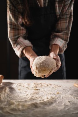 Fırına koymadan önce hamur tutan kadın fırıncının ellerini kapat..