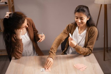 Kâğıt oynayan iki kadın hafta sonu eğleniyor, evde boş vakit geçiriyor. Boşluğu kopyala