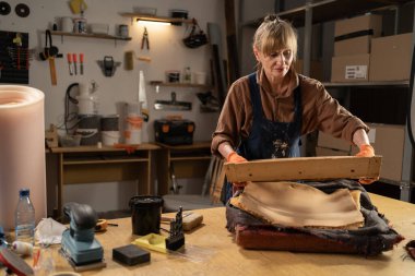 Yaşlı kadın marangoz sandalye sökme işlemi için çalışıyor. Eski mobilyaların onarımı ve restorasyonu. Boşluğu kopyala